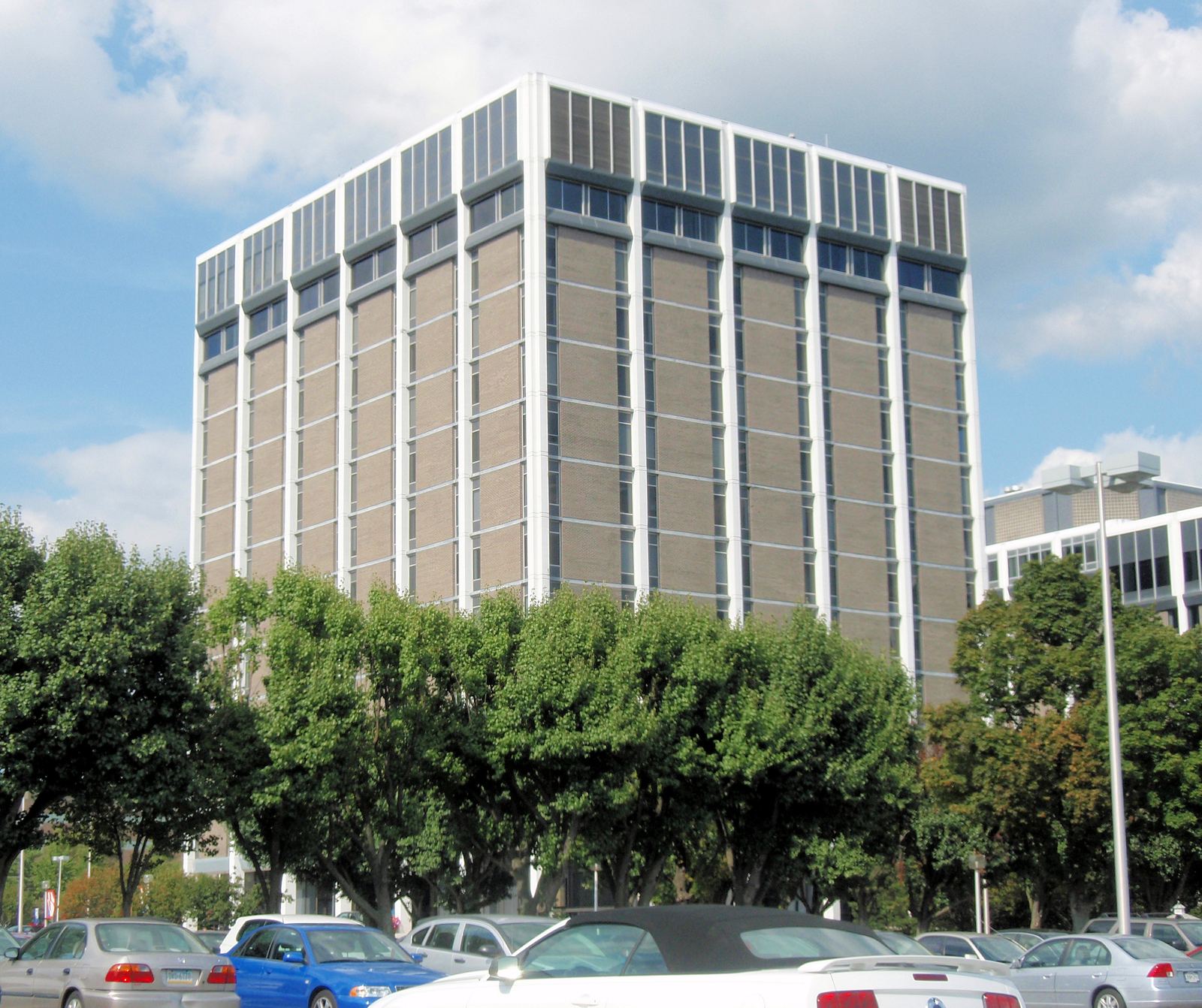 A white eleven-story office tower with trees and a parking lot in front, in Hunt Valley, Maryland